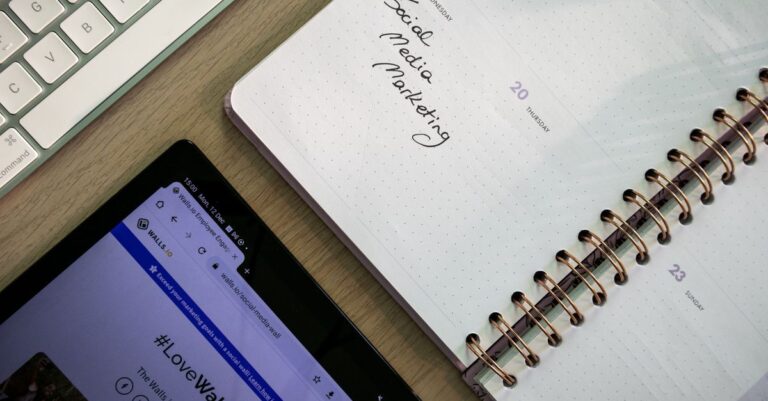 Vista desde arriba de un cuaderno, tableta y teclado utilizados para la planificación de marketing en redes sociales.